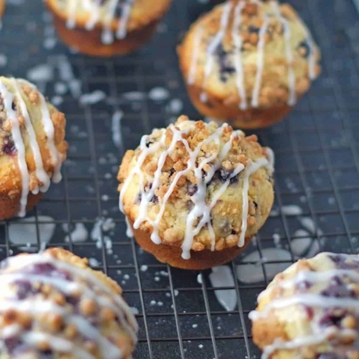 Cornmeal blueberry muffins topped with streusel and glaze.