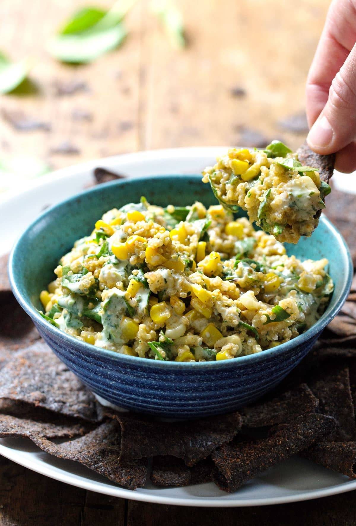 Jalapeño Quinoa Corn Dip on a tortilla chip.